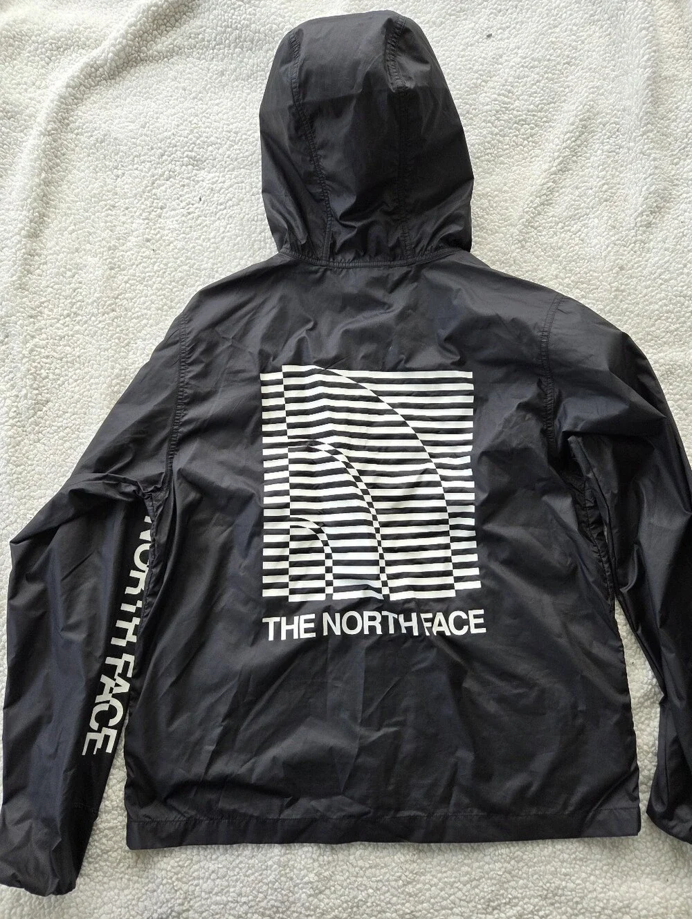 The North Face Optical Cyclone windbreaker features a distinctive optical illusi